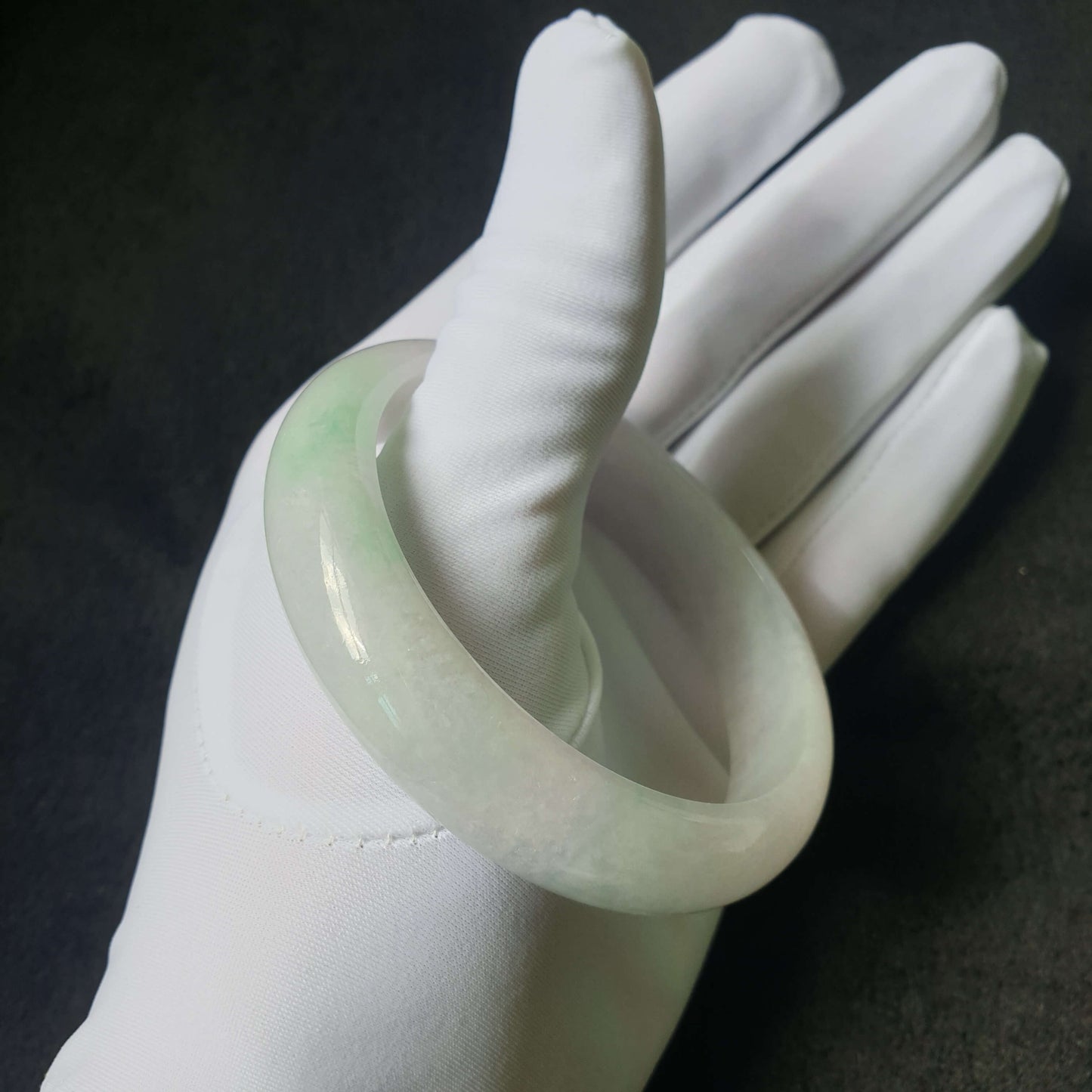 Jade bangle worn on wrist for size and comfort reference